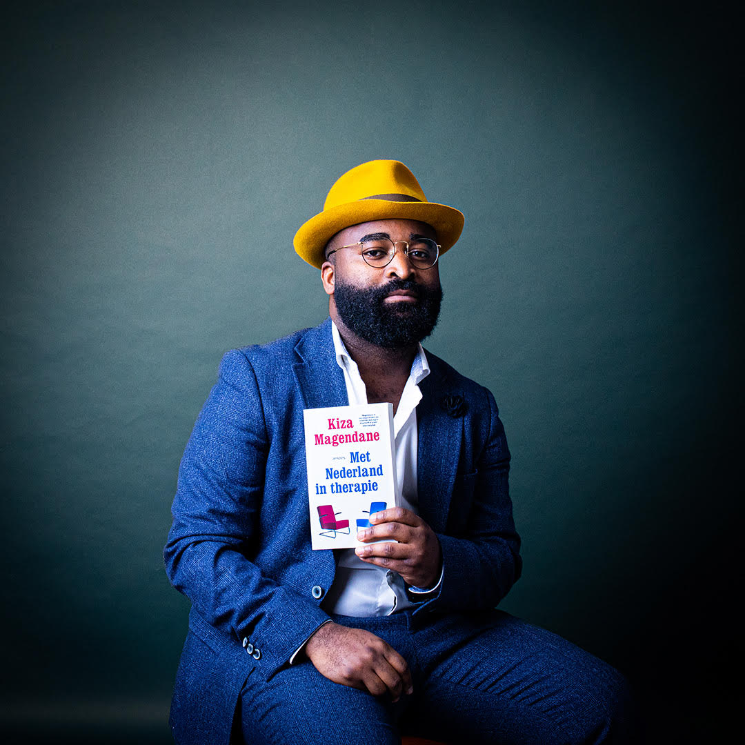 Kiza Magendane met zijn boek Met Nederland in therapie